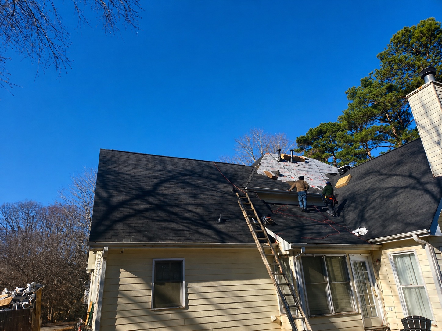 Roof replacement in progress — tear-off and new shingles being installed